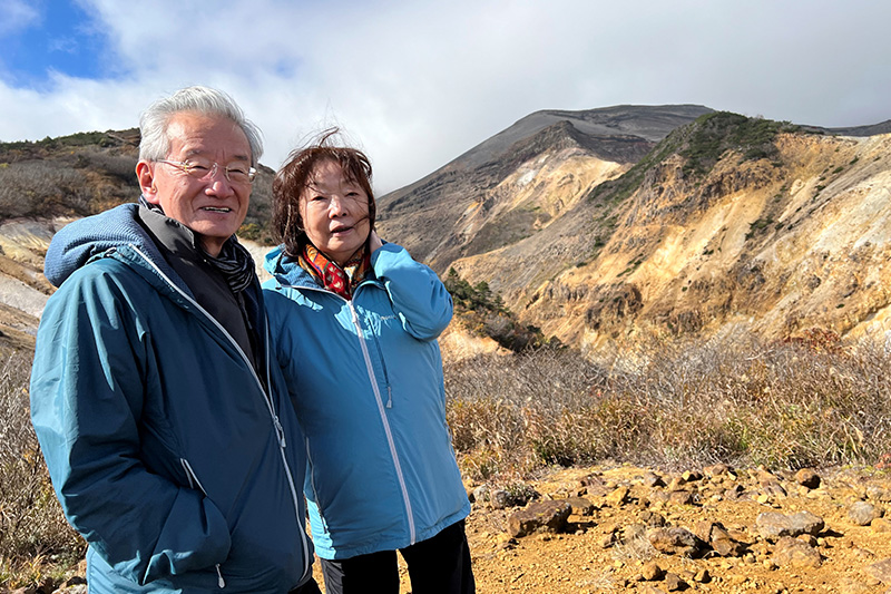 大黒天を背景に立つ近森正幸相談役と奥様